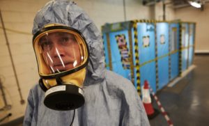 An asbestos analyst wears protective gear prior to beginning a four-stage clearance inspection