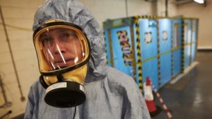 An asbestos analyst wears protective gear prior to beginning a four-stage clearance inspection